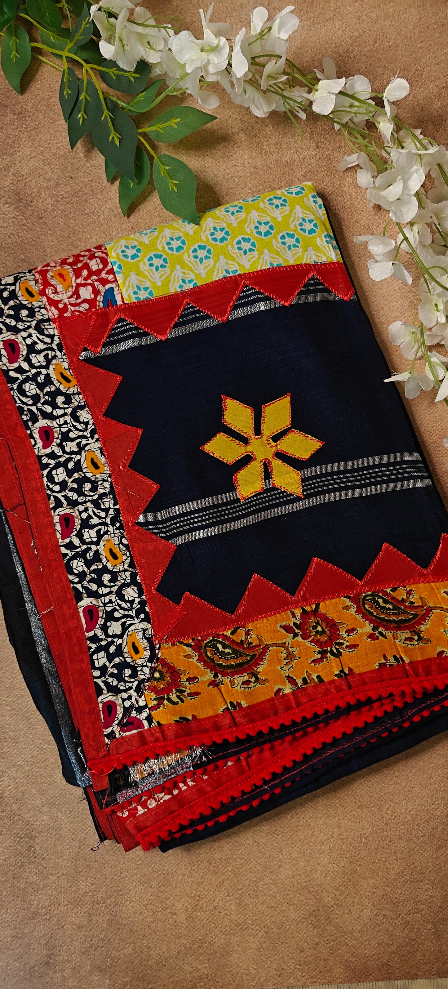 Navy blue cotton saree featuring vibrant appliqué panels and zigzag borders, artisan-made ethnic wear.