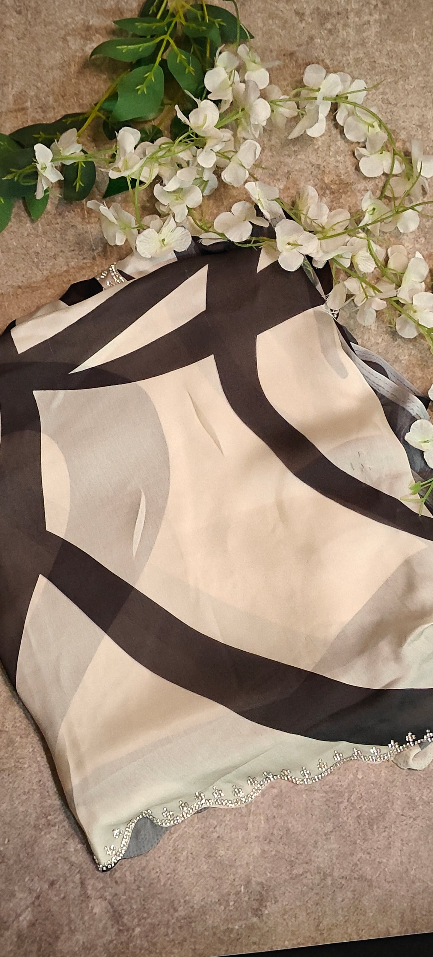 Black satin-georgette saree with abstract line motifs on white base and subtle embellishments, elegant contemporary attire.
