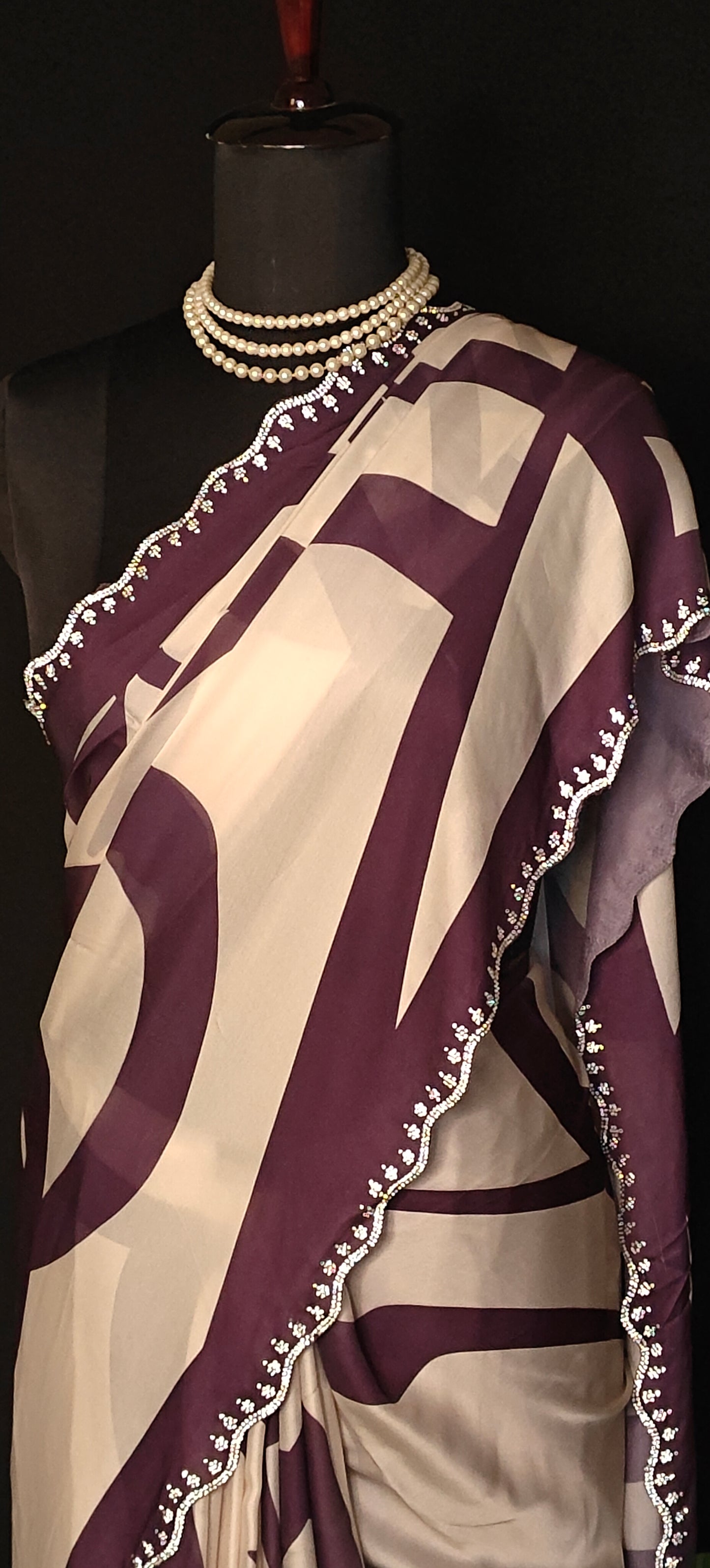 Purple-accented satin-georgette saree featuring abstract line design on white base with delicate border, stylish festive saree.