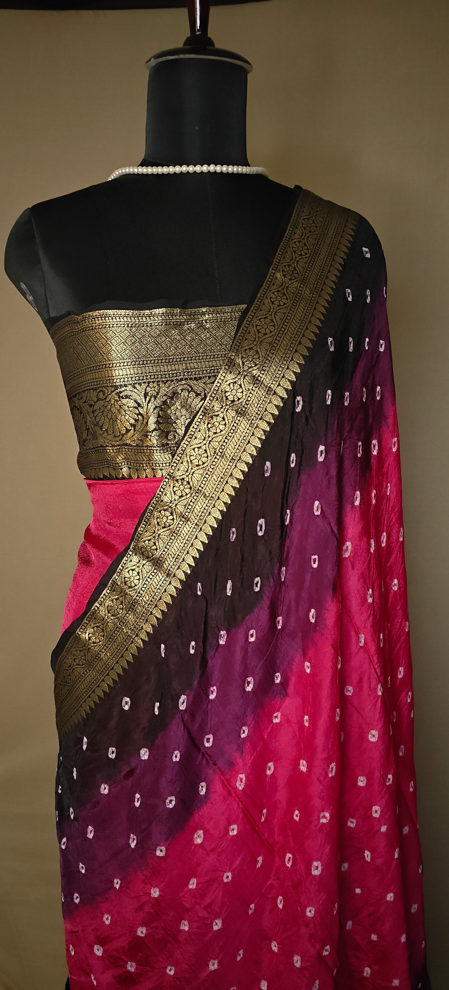 Magenta silk saree with broad golden zari border, styled on mannequin.