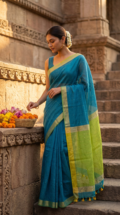 A model standing on the stone steps of an ancient stepwell during golden hour, showcasing the rich blue linen drape and lime green organza pallu