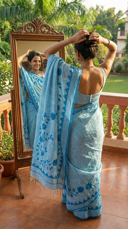 Woman in a blue-floral-cotton-applique-saree, in front of a mirror outdoors.
