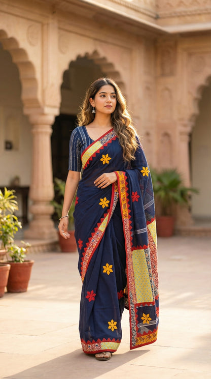 Woman wearing a navy blue cotton saree featuring vibrant appliqué panels and zigzag borders, artisan-made ethnic wear in an outdoor setting.