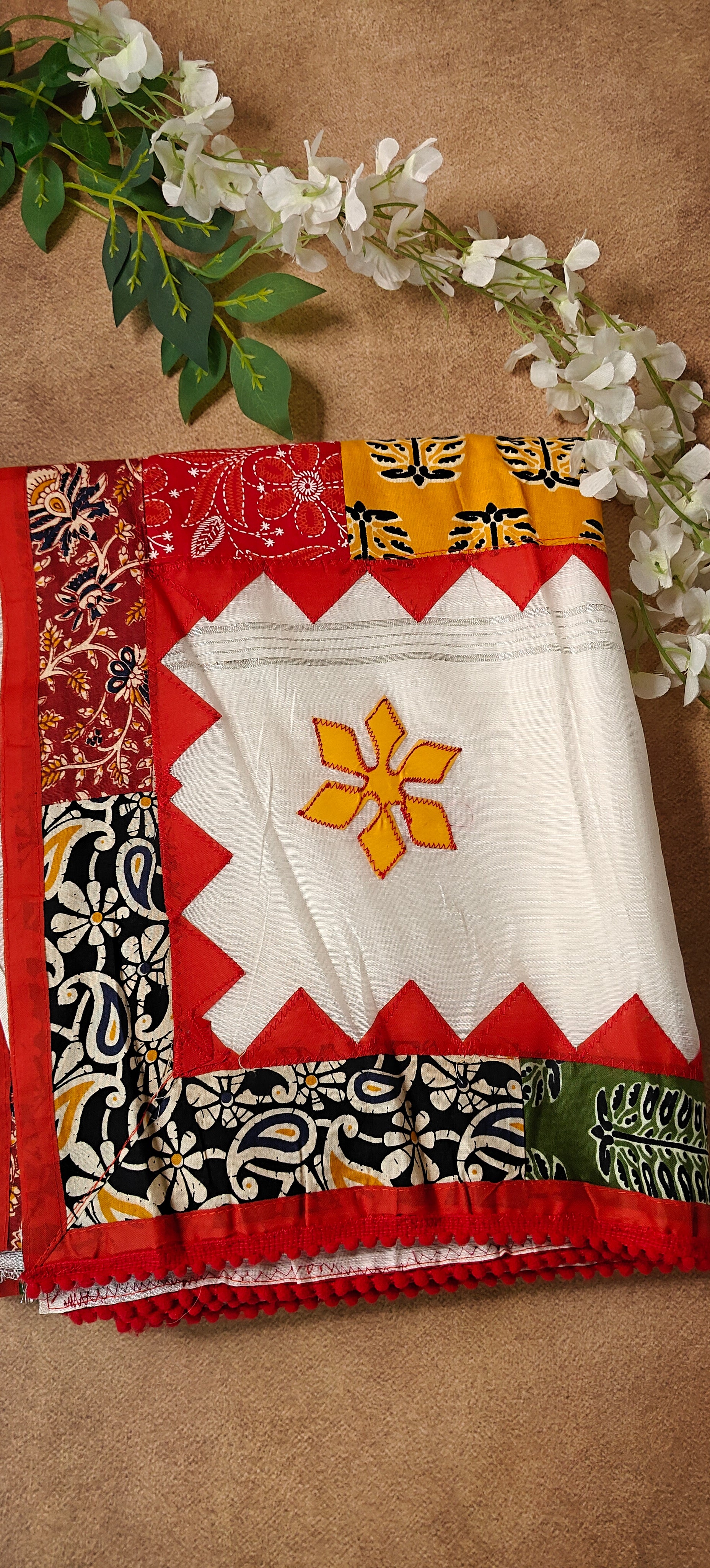 White cotton saree with colorful appliqué patchwork and embroidered motifs, handcrafted traditional Indian attire.