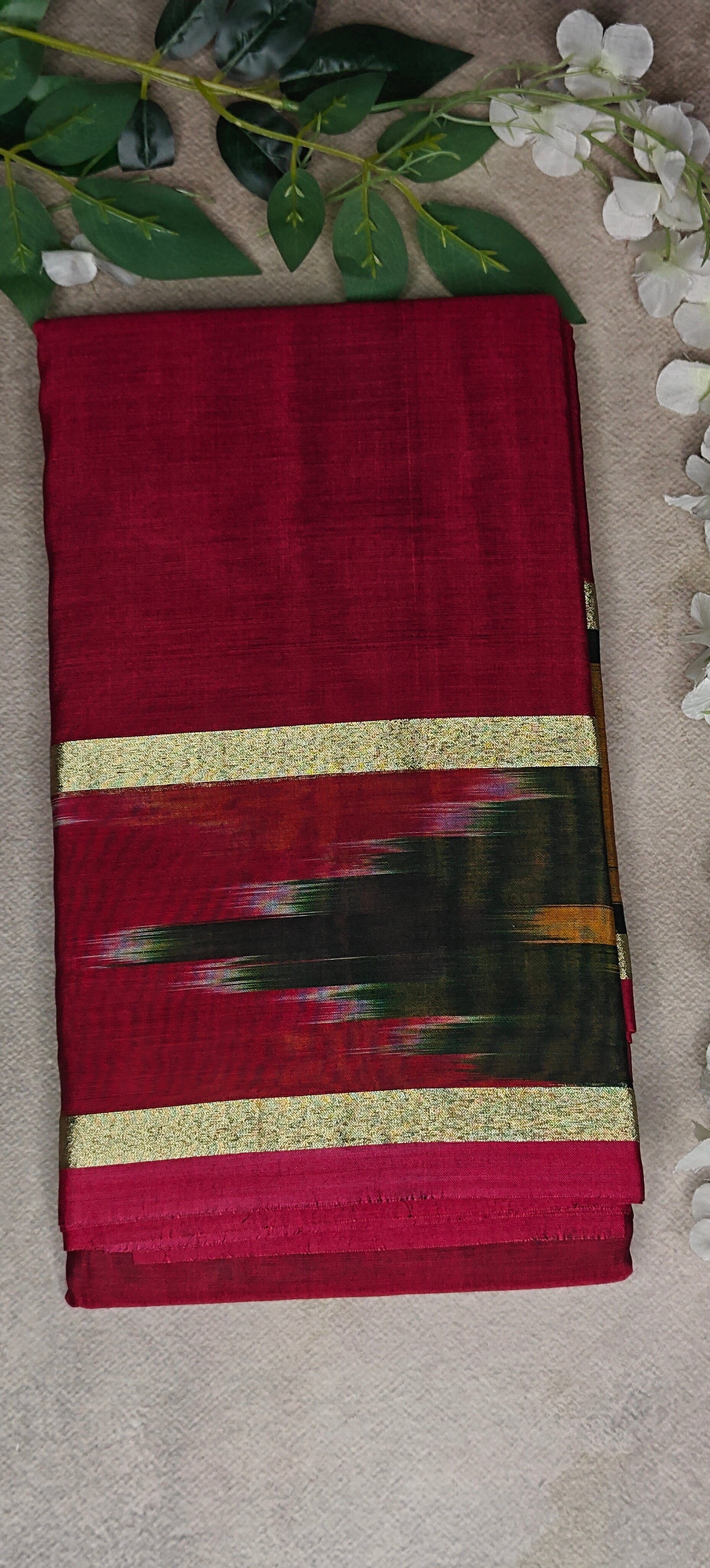 Wine cotton saree with abstract brushstroke border and golden trim, styled on mannequin with neutral background.
