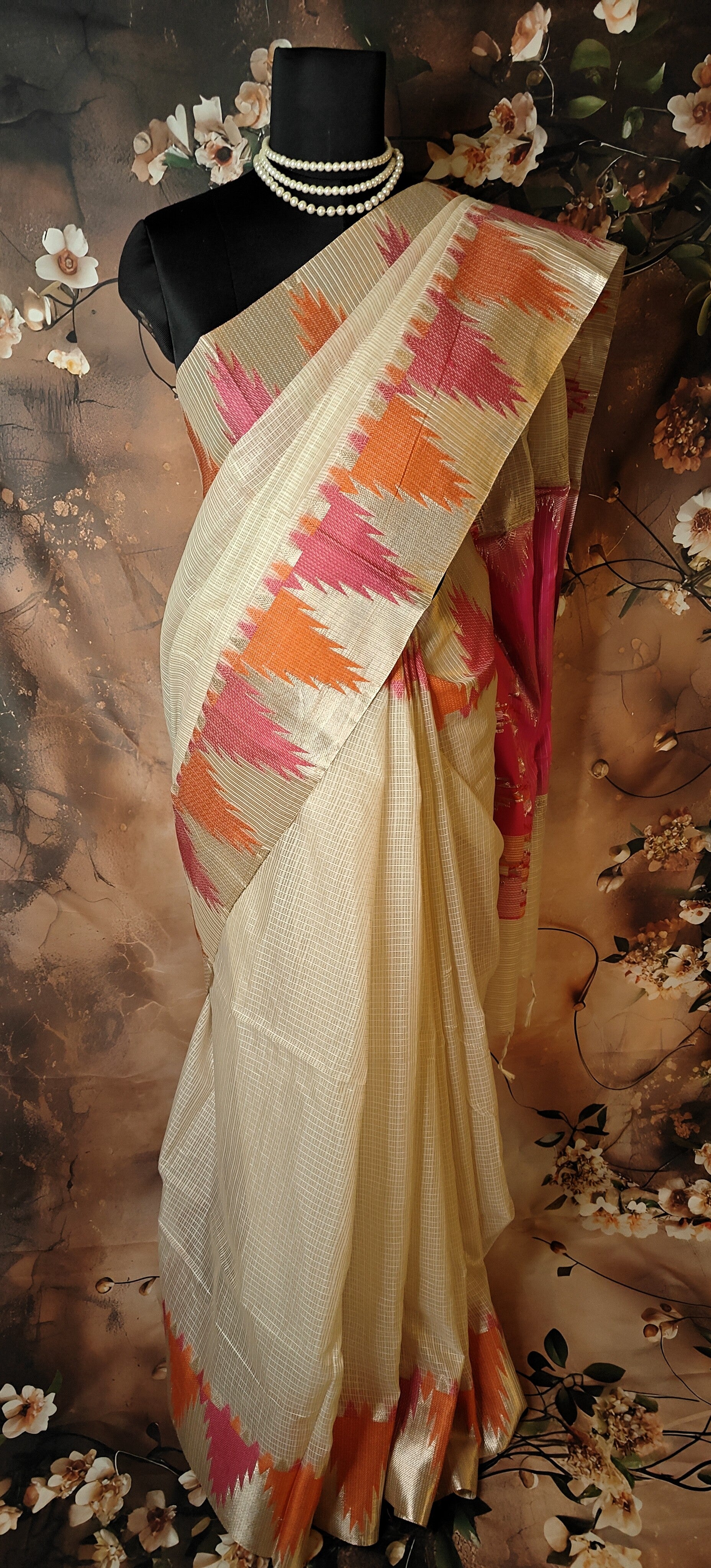 Kota Blend Saree – Cream Base with Vibrant Zigzag Pallu saree on a mannequin against a floral background.