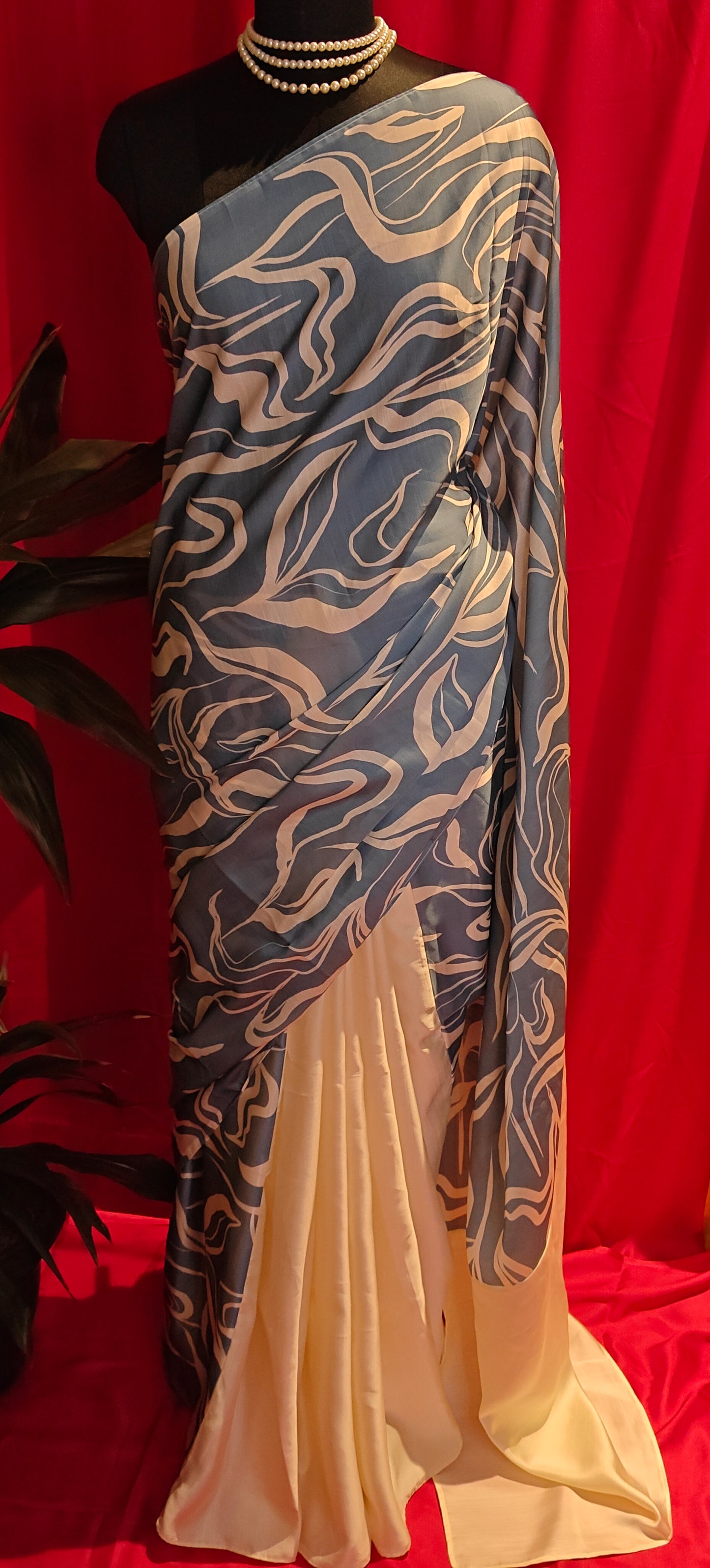 Designer Silk Saree – Blue Abstract Print with Cream Pallu draped on a mannequin.