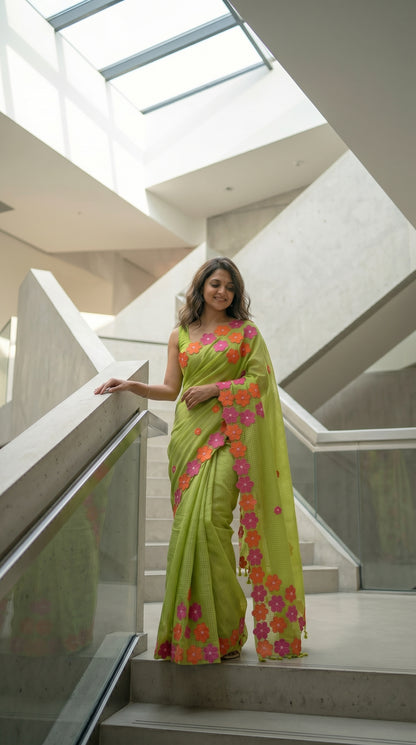 Woman in a green-mirror-work-kota-saree, standing on a staircase.