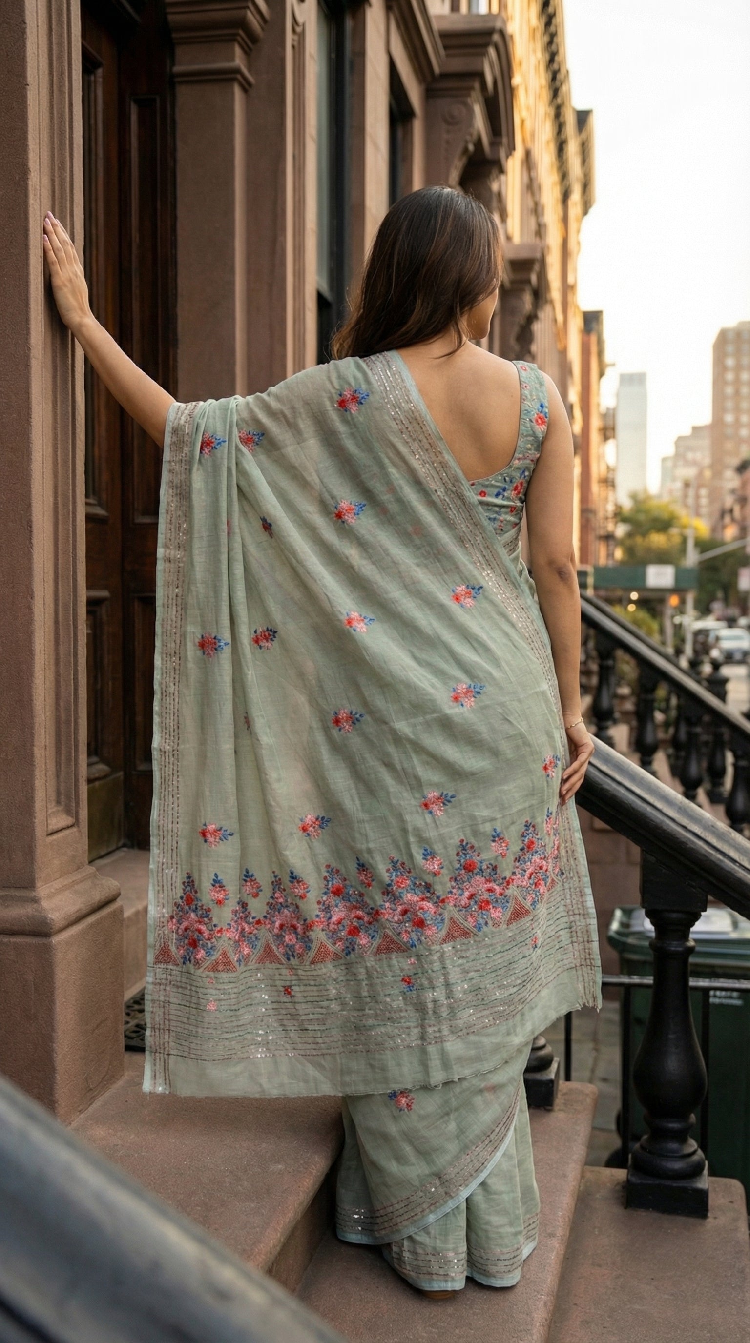 Woman wearing a grey-chanderi-kantha-saree, standing on a staircase.
