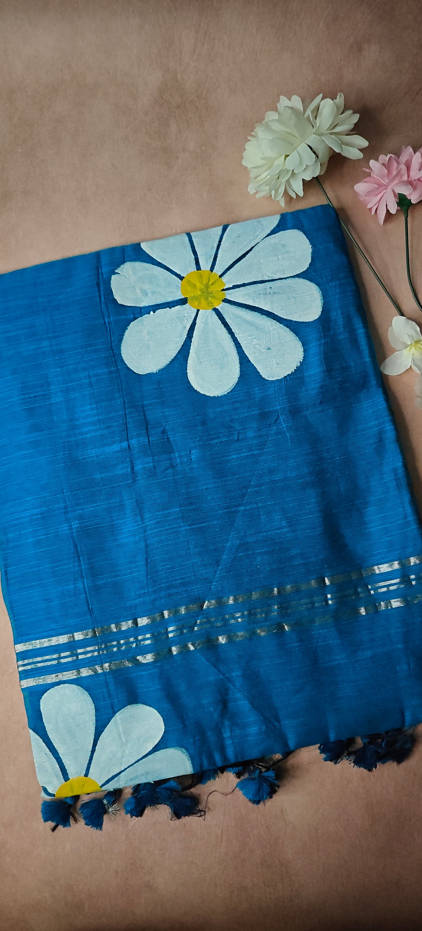 Blue cotton saree with white and yellow sunflower motifs, hand-painted artisan saree for cultural occasions.