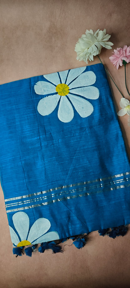 Blue cotton saree with white and yellow sunflower motifs, hand-painted artisan saree for cultural occasions.