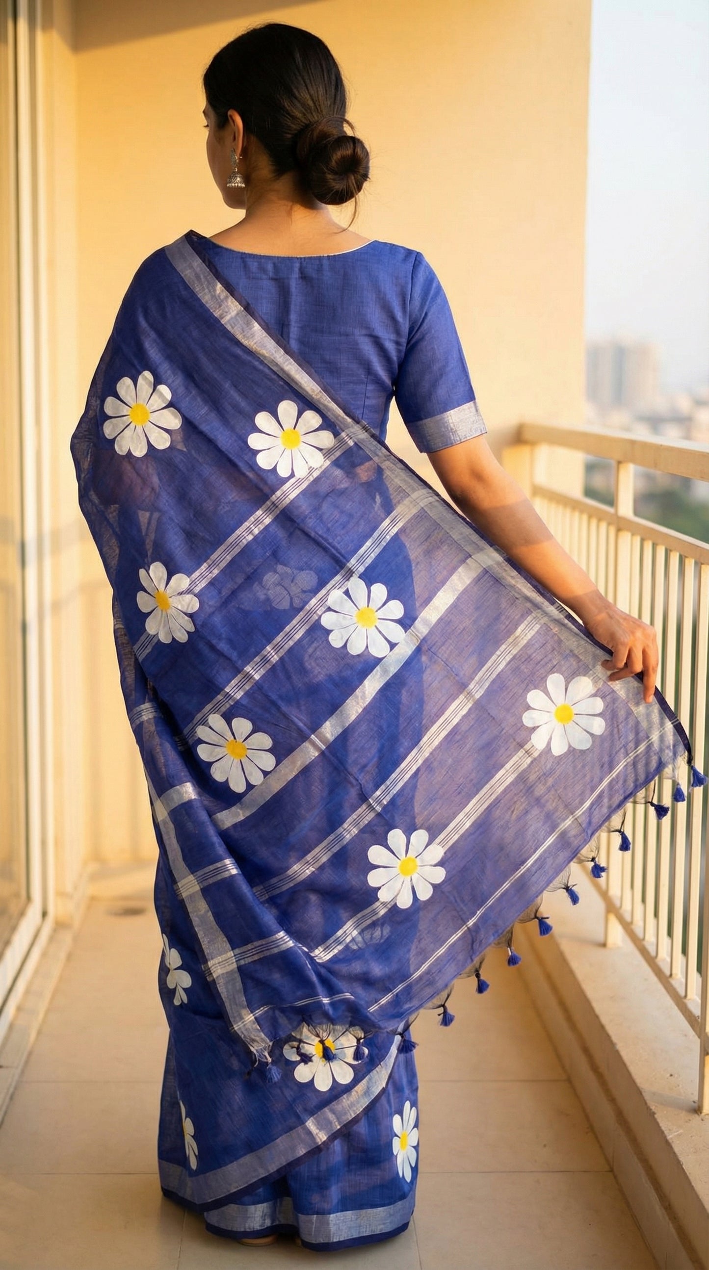 Woman wearing Navy cotton saree with hand-painted sunflower motifs and tassel border, breathable traditional Indian attire.