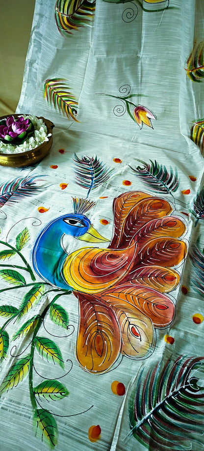 White cotton saree with vibrant hand-painted peacock and floral motifs, breathable artisan ethnic attire.