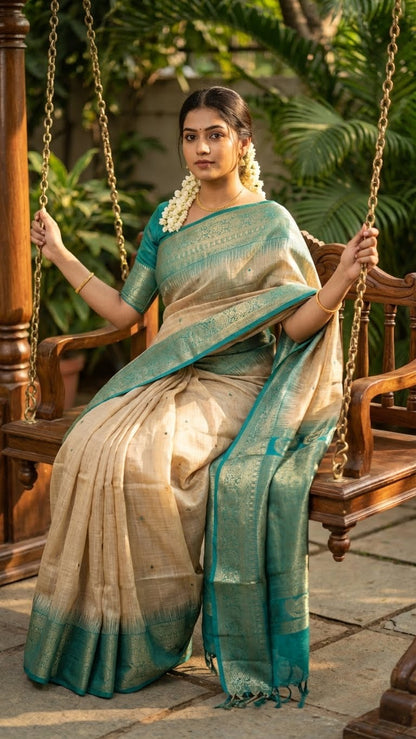 Woman in a beige Hasthkala blended silk saree featuring a royal blue gold zari border and temple motifs sitting on a swing.