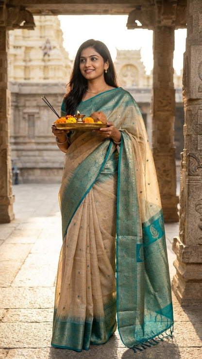 Woman in a beige Hasthkala blended silk saree featuring a royal blue gold zari border and temple motifs holding offerings in front of ancient temple architecture.