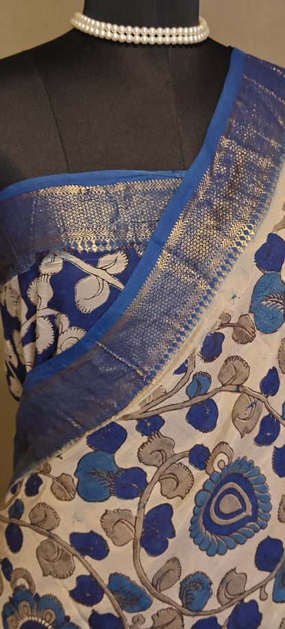 Indigo silk saree with Kalamkari-inspired digital print and golden border on a mannequin, on a plain background.