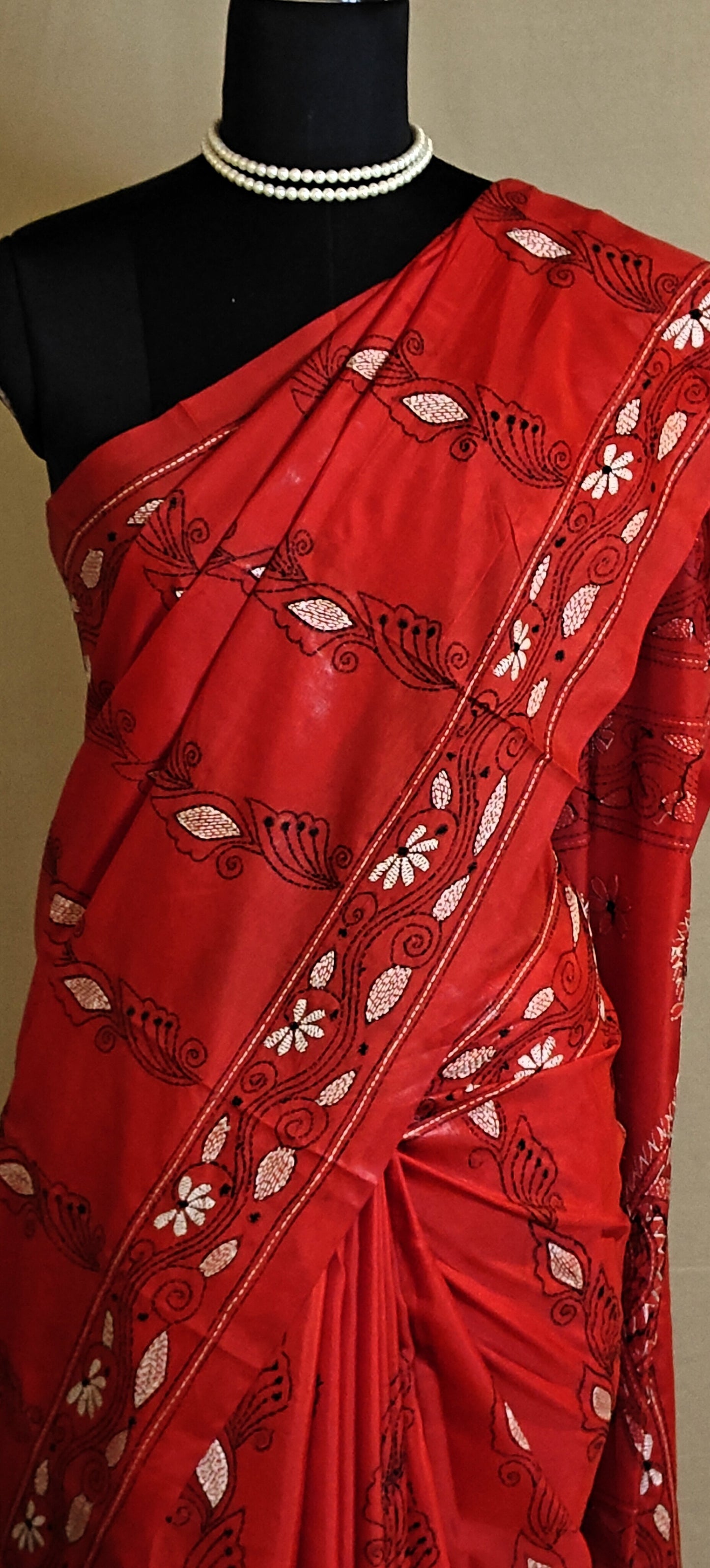 Kantha-Stitched blended silk Saree – Red with White & Black Floral Embroidery saree with white patterns on a mannequin against a plain background.