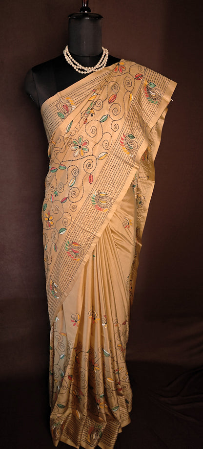 Handcrafted Kantha-Stitched Cotton Saree – Gold with Multicolor Floral & Paisley Embroidery on a mannequin with dark background.
