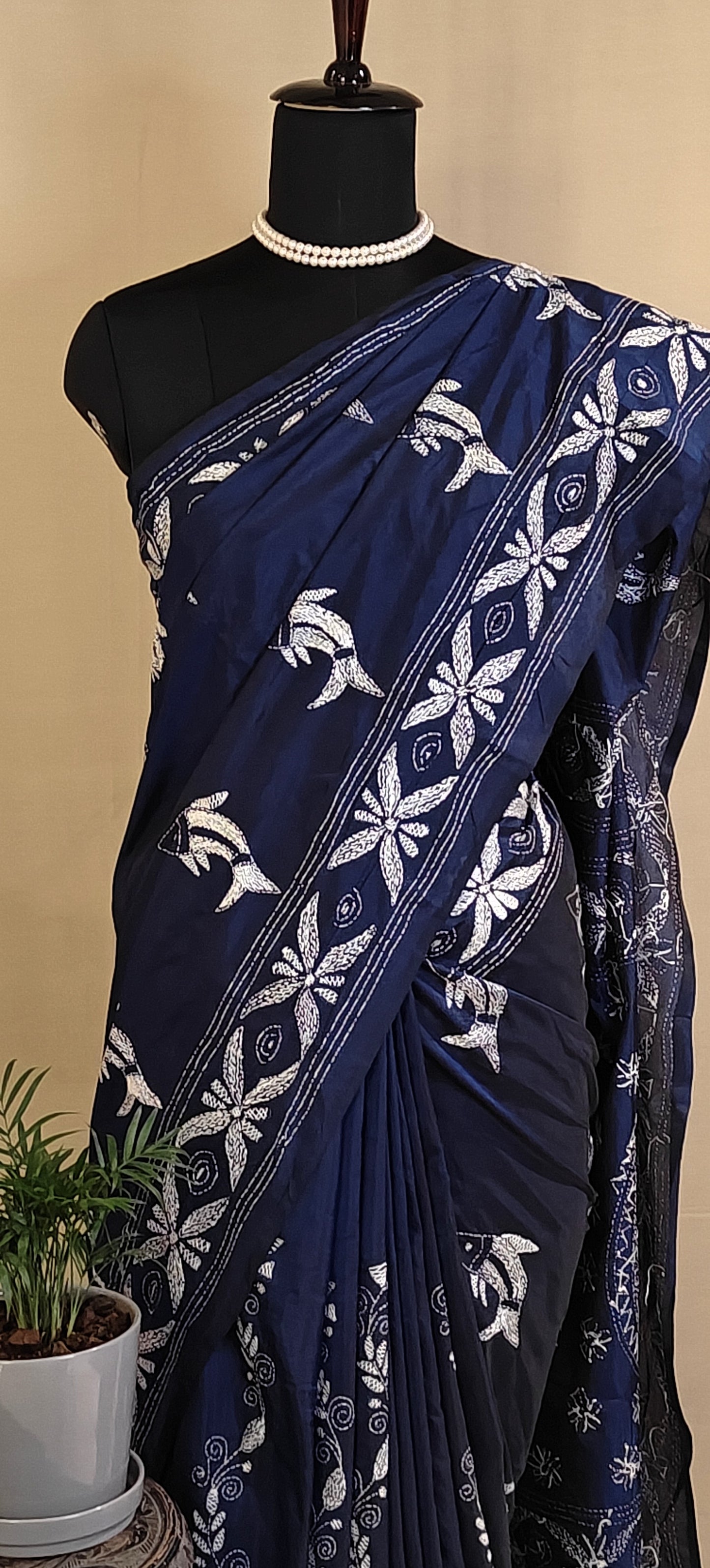 Handcrafted Kantha-Stitched Cotton Saree – Indigo Blue with White Bird & Floral Motifs saree with white patterns on a mannequin against a beige background.