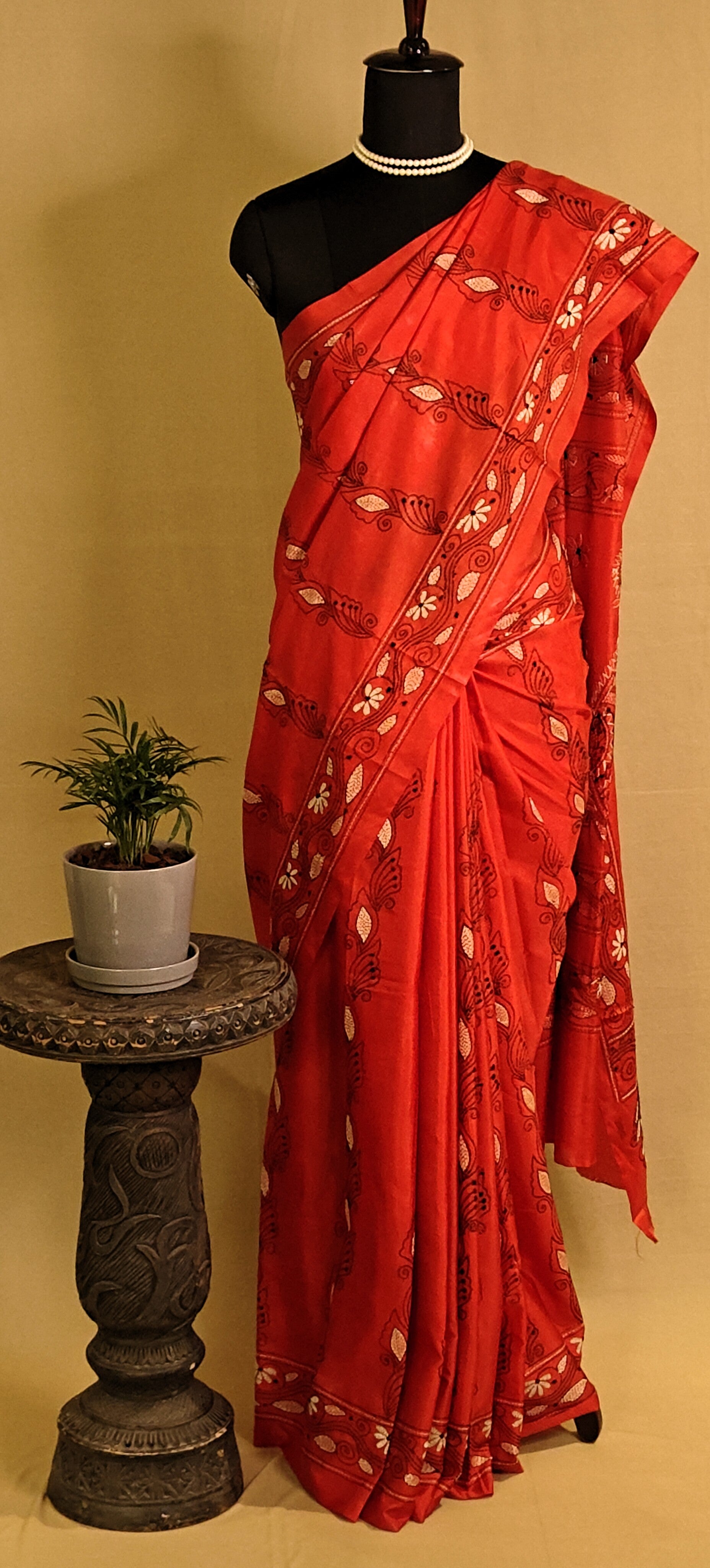 Handcrafted Kantha-Stitched Cotton Saree – Red with White & Black Floral Embroidery saree with white patterns on a mannequin against a plain background.