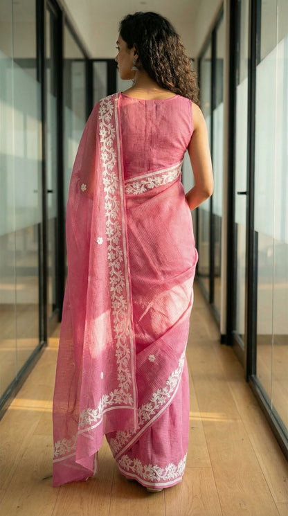 Woman wearing a Pink Kota saree with delicate white appliqué embroidery, sheer and breathable handcrafted ethnic saree in an indoor setting.