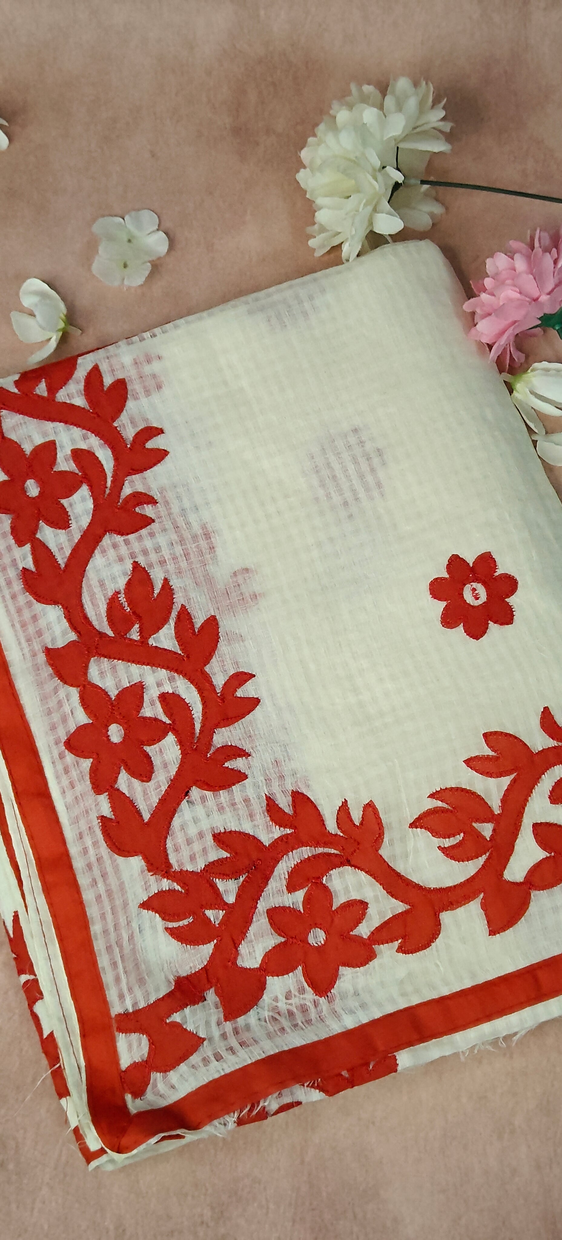 White Kota saree featuring intricate appliqué work with floral and paisley motifs in red, traditional festive attire.