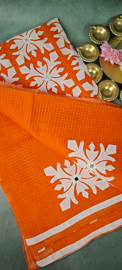 Orange Kota saree with symmetrical white floral appliqué and soft texture, handcrafted traditional Indian saree.