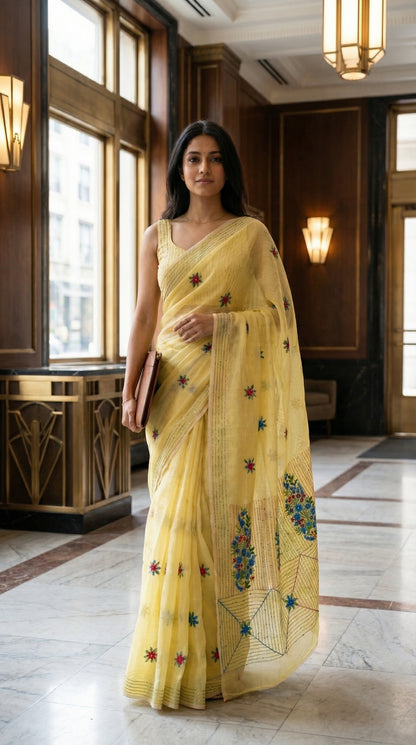 Woman in a lemon-yellow-chanderi-kantha-saree, standing in an elegant interior setting.