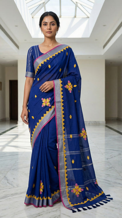 Navy linen cotton saree with multicolor floral appliqué and hand embroidery, artisan-crafted traditional Indian saree, with floral patterns in an indoor setting.