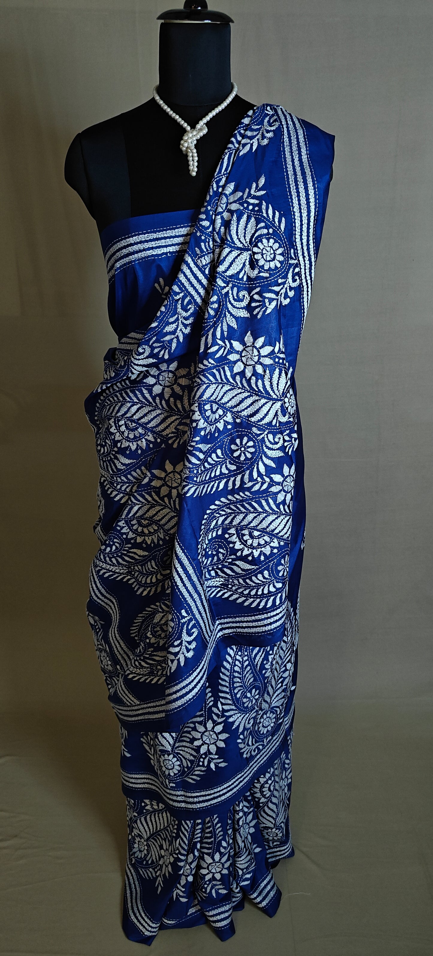 Luxury Kantha-Stitched Silk Saree – Deep Blue with White Paisley & Floral Bands saree on a mannequin with neutral background.