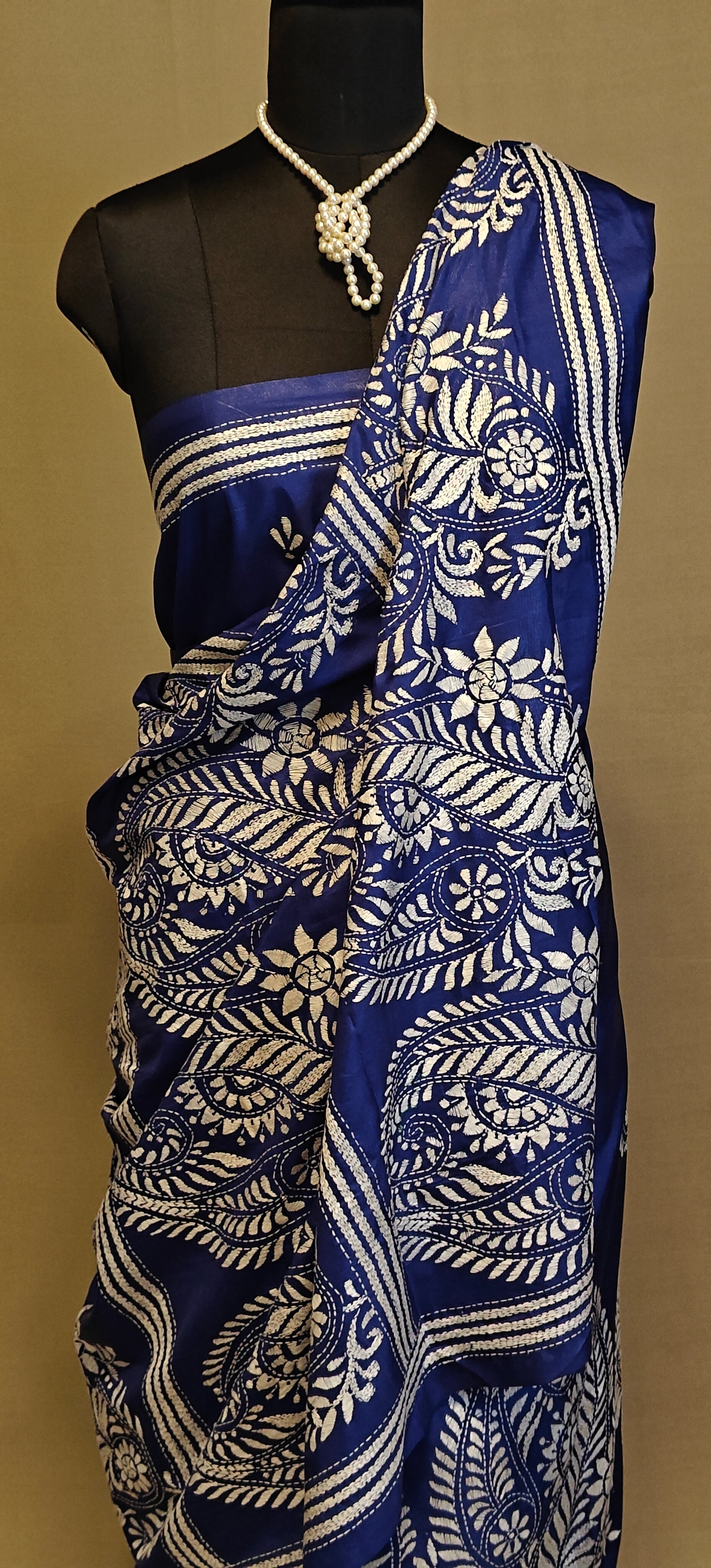 Luxury Kantha-Stitched Silk Saree – Deep Blue with White Paisley & Floral Bands saree on a mannequin with neutral background.