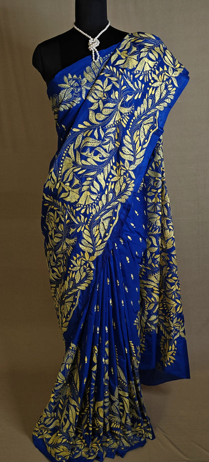 Luxury Kantha-Stitched Silk Saree – Royal Blue with Golden Floral Embroidery saree with gold leaf patterns on a mannequin against a neutral background.