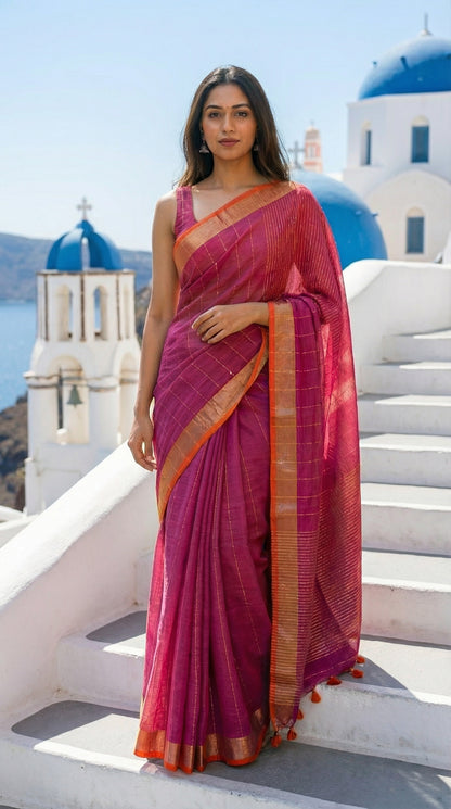 Woman in a magenta-cotton-linen-saree-Zari, with a blue and white building in the background