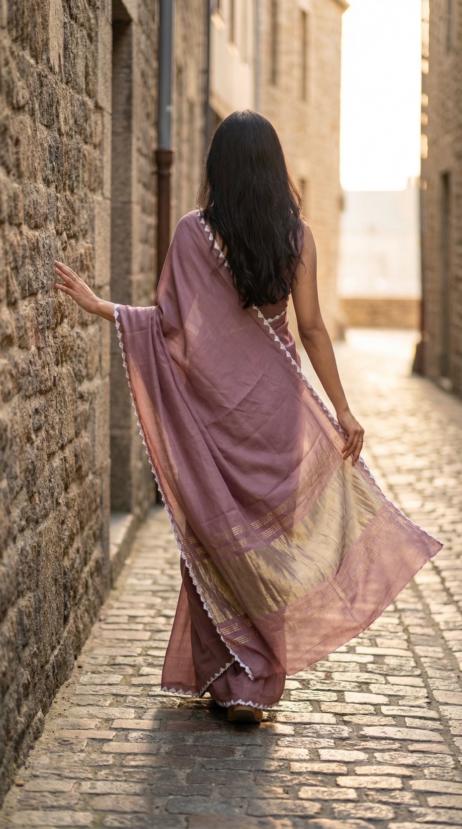 Woman in a mauve-modal-silk-saree-lagdi-patta-pallu, walking in a street.