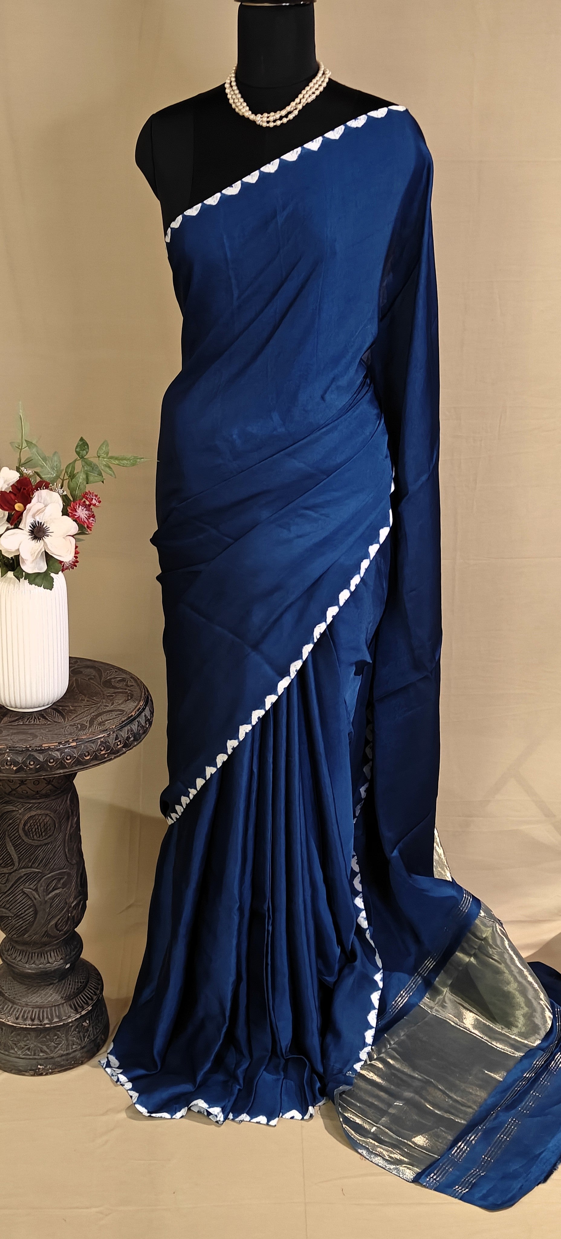 Blue Modal Silk Saree with Lagdi Patta Pallu saree with white border on a mannequin against a beige background.
