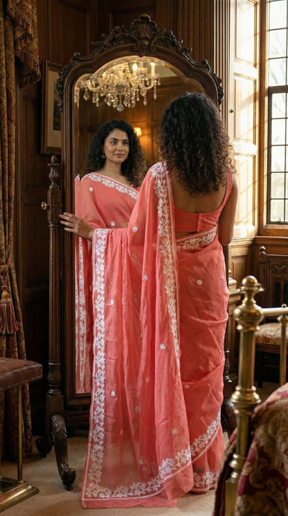 Woman in a peach-kota-doria-saree, standing in front of a mirror in an elegant room.