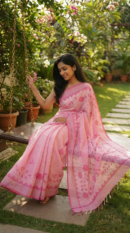 Woman in a pink-floral-cotton-applique-saree, sitting on a swing in a garden