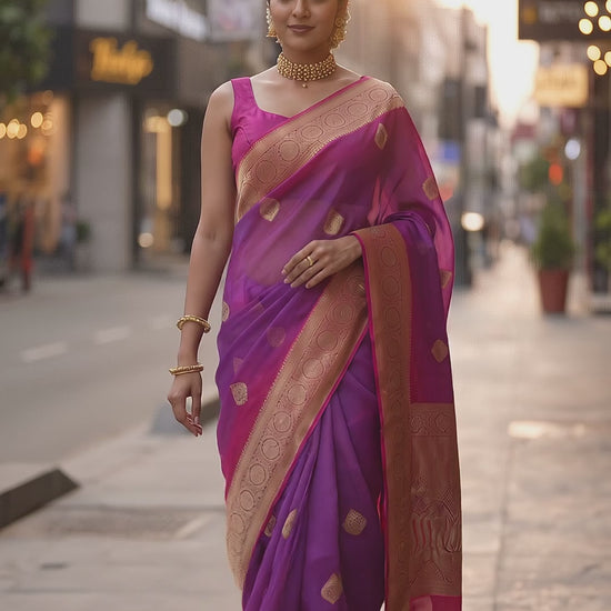 A full-length front portrait of a woman walking gracefully on a street and taking a swirl, beautifully displaying the structured royal drape, golden buttis, and detailed pink zari border of her purple handloom saree