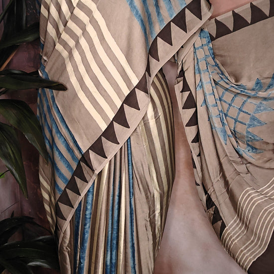 Ajrakh Modal Silk Saree – Beige & Brown with Blue Stripes and Triangular Border saree with geometric patterns on a mannequin.