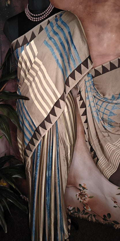 Ajrakh Modal Silk Saree – Beige & Brown with Blue Stripes and Triangular Border saree with geometric patterns on a mannequin.