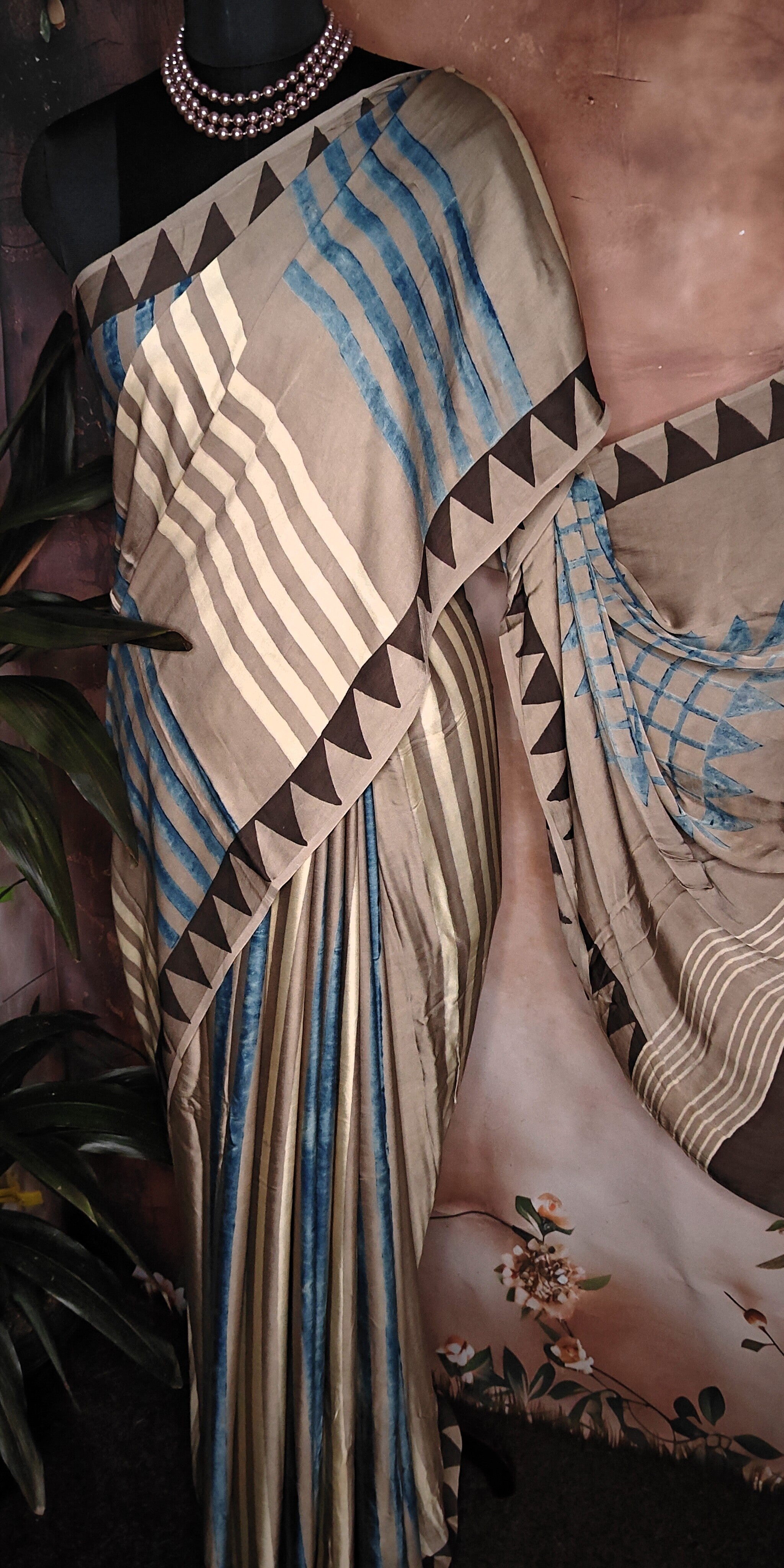 Ajrakh Modal Silk Saree – Beige & Brown with Blue Stripes and Triangular Border saree with geometric patterns on a mannequin.