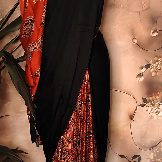 Ajrakh Modal Silk Saree – Black with Red Tribal Motif Pallu and Geometric Pleats saree draped on a mannequin.