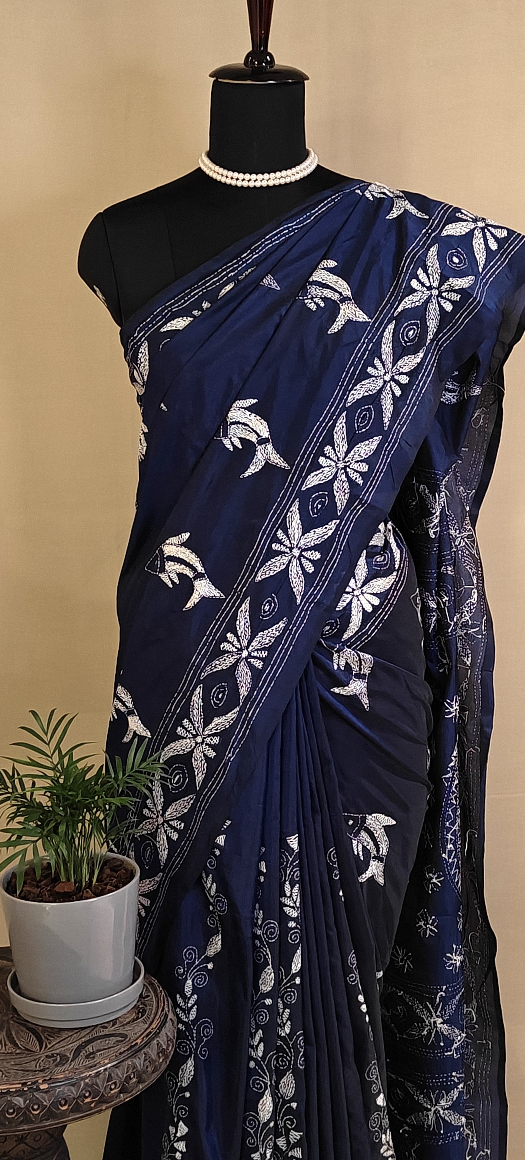 Handcrafted Kantha-Stitched Cotton Saree – Indigo Blue with White Bird & Floral Motifs saree with white patterns on a mannequin against a beige background.
