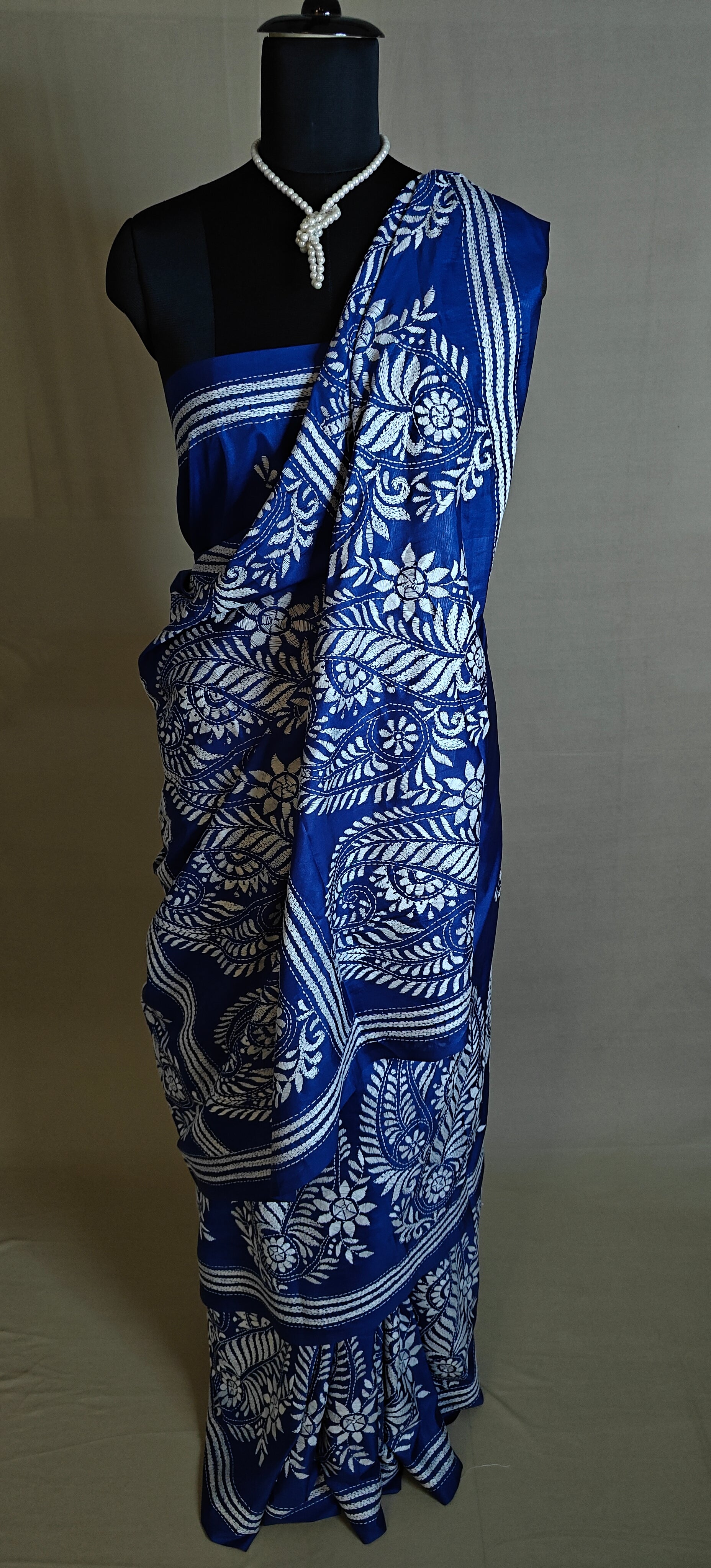 Luxury Kantha-Stitched Silk Saree – Deep Blue with White Paisley & Floral Bands saree on a mannequin with neutral background.