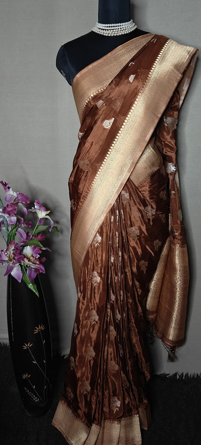 Copper-brown and beige Mashru silk saree with floral embroidery, displayed flat with decor accents