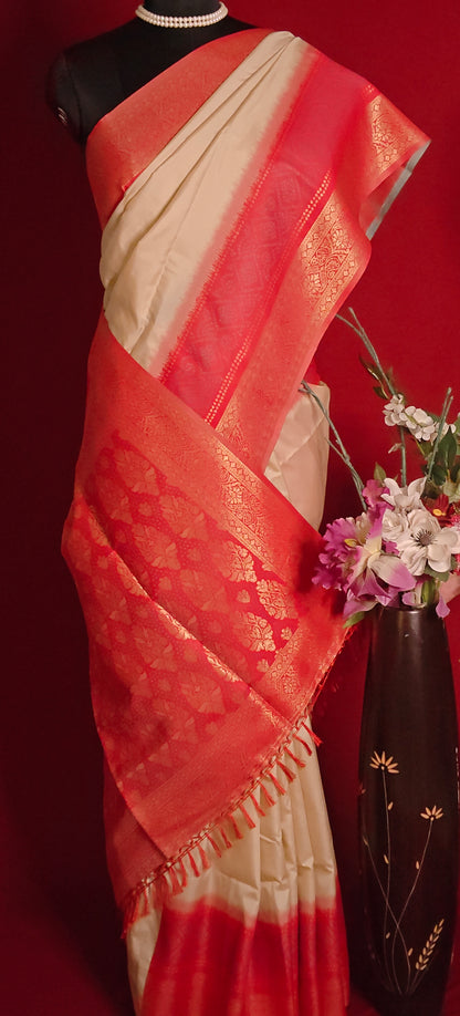 Pure silk cream saree with red zari border and golden motifs, styled on mannequin showcasing the pink pallu with a vase of flowers against a red background.