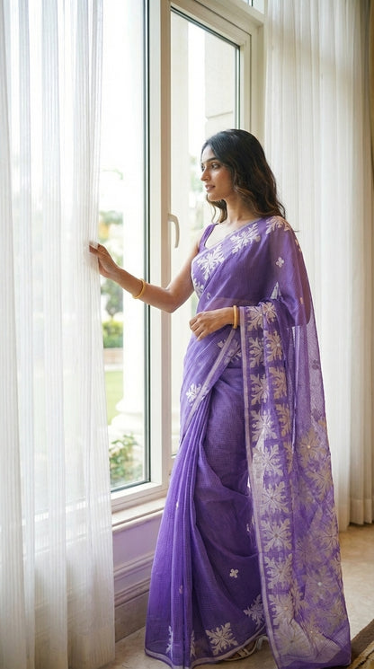 Woman in a purple-applique-kota-saree, standing by a window with white curtains