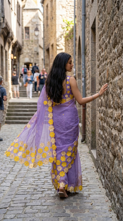 Woman in a purple-mirror-work-kota-saree, walking down a stone alleyway.
