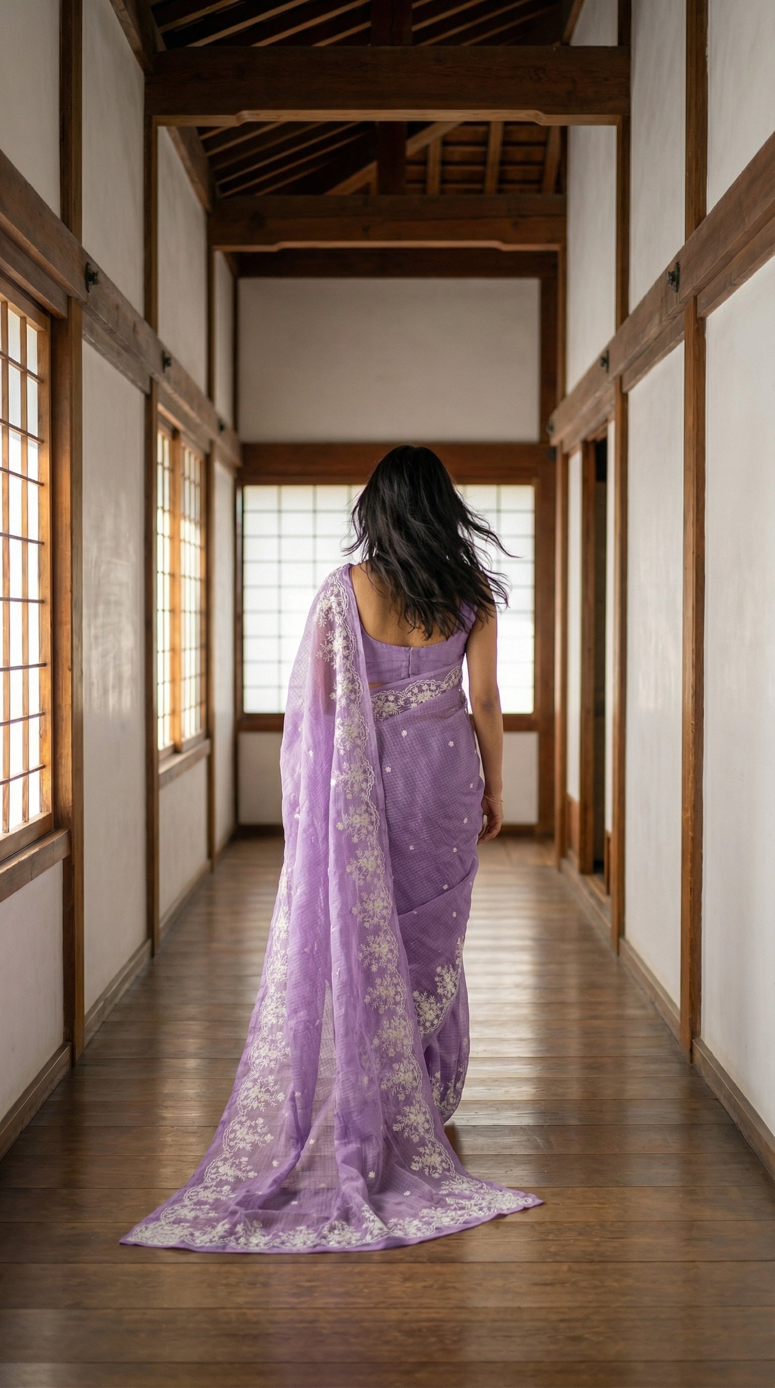 Woman in a purple-resham-kota-cotton-saree, walking through a traditional Japanese room with wooden floors and sliding doors.