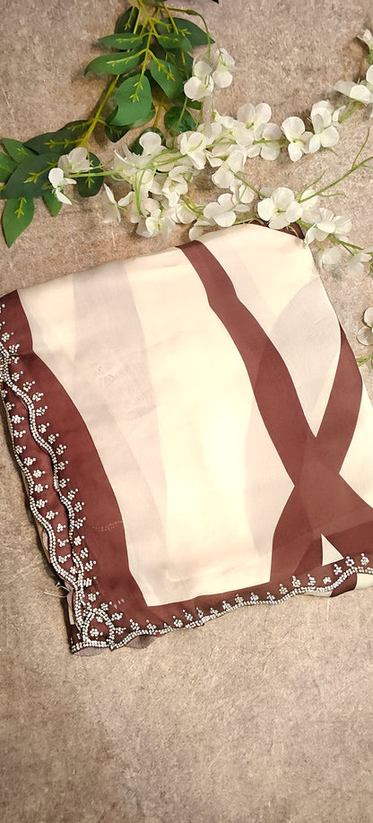 Brown satin-georgette saree with abstract line motifs on white base and subtle embellishments, elegant contemporary attire.